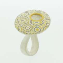 22k gold, 18k white gold and silver mokume gane discus with cutaway detail and diamond presented on a sterling silver curved band.