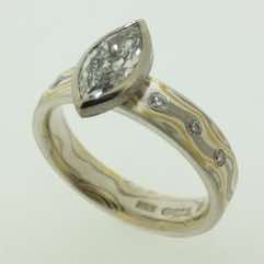 22k gold, 18k white gold and silver mokume gane 5mm flat band with flush set diamonds and a marquise cut diamond in an 18k white gold setting