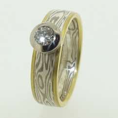 18k white gold and silver mokume gane band with 18k yellow gold rails and brilliant cut diamond in an 18k white gold rubover pod setting