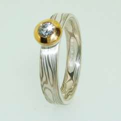 18k white gold and silver mokume gane band with brilliant cut diamond in 22k gold and silver rubover pod setting