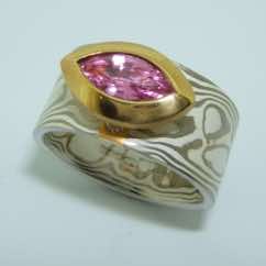 18k white gold and silver mokume gane wide flat band with a marquise cut pink sapphire in a 22k gold rub-over boat setting. POA.