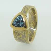 18k white and yellow gold mokume gane tapered band with a trillion cut aquamarine set in an 18k yellow gold rub-over setting.