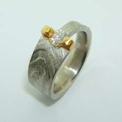 Platinum textured tapered band with brilliant cut diamond in a 22k gold bar setting.  POA.