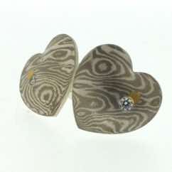 18k white gold and silver heart shaped stud earrings with 22k gold and diamond details.