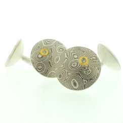 18k white gold and silver mokume gane discus cufflinks with 22k gold and diamond details.  Sterling silver rod and back.