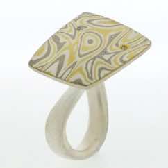 22k gold, 18k white gold and silver mokume gane fower neukit with diamonds presented on a sterling silver curved band.