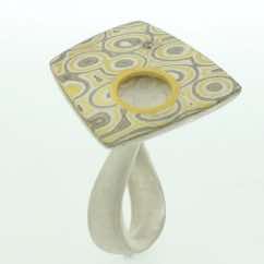 22k gold, 18k white gold and silver mokume gane fower neukit with cutaway detail and diamond presented on a sterling silver curved band.