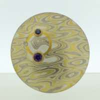 Transit patterned 22k gold, 18k white gold and silver mokume gane discus brooch (31mmø) with 22k gold halo and sapphire and diamond details.