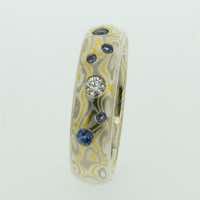 22k gold, 18k white gold and silver mokume gane full court band flush set with diamonds and blue sapphires