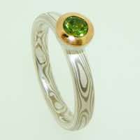 18k white gold and silver mokume gane full court band with a round demantoid garnet in a 22k gold and silver rub-over pod setting