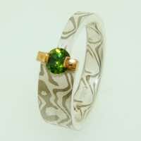 18k white gold and silver mokume gane tapered band with a demantoid garnet in a 22k gold bar setting