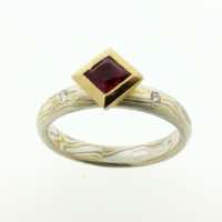 22k gold, 18k white gold and silver mokume gane full court band with flush set diamonds and a square ruby in a 22k gold rub-over box setting.
