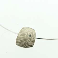 18k white gold and silver mokume gane small fower neukit pendant with flush set diamond.  