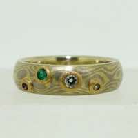 18k white and yellow gold mokume gane full court band set with emerald, amethyst, aquamarine and diamond in low 22k gold rub-over settings.