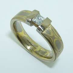 18k white and yellow gold mokume gane 5mm flat band with a princess cut diamond in an 18k white gold double bar setting