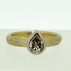 18k white and yellow gold mokume gane fine full court band with a pear shaped diamond set in 18k white gold