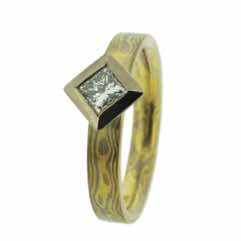 18k white and yellow gold mokume gane 3mm flat band with a princess cut diamond in an 18k white gold box setting