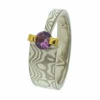 18k white gold and silver mokume gane tapered band with a lilac sapphire in a 22k gold bar setting