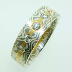18k white gold and silver mokume gane flat ring with a five brilliant cut diamonds set in 22k gold strip.<br/>