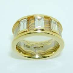 18k white and yellow gold mokume gane wide flat band with 18k yellow gold rails set with 3 baguette diamonds