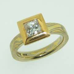 18k white and yellow gold mokume gane 3mm flat band with a princess cut diamond in a 22k gold box setting