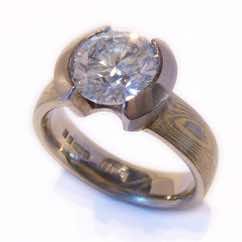 18k white and yellow gold mokume gane court band with brilliant cut diamond in 18k white gold open tapered rubover setting