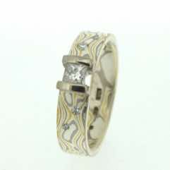 22k gold, 18k white gold and silver mokume gane 5mm flat band with flush set diamonds and a princess cut diamond in an 18k white gold double bar setting