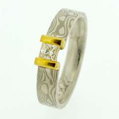 18k white gold and silver mokume gane 5mm flat band with a princess cut diamond in a 22k gold double bar setting