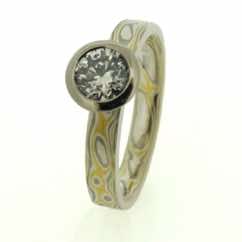 Ring in 22k, 18k White Gold And Silver Mokume Gane with brilliant cut diamond in polished rub-over setting