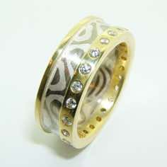 18k white gold and silver mokume gane 3mm flat band with 18k yellow gold rails and flush set with 1.5pt brilliant cut diamonds.<br/>