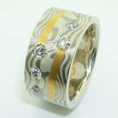 18k white gold and silver mokume gane wide ring with 22k gold spiral detail and flush set with 2x10pt, 2x6pt and 2x3pt brilliant cut diamonds.<br/>
