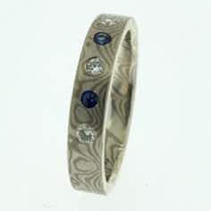 18k white gold and silver mokume gane 3mm flat band with flush set blue sapphires and diamonds.<br/>