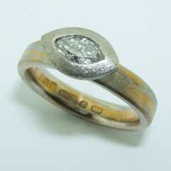 Platinum and 24k gold mokume gane narrow flat band with a marquise cut diamond in a platinum setting