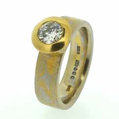 Platinum and 22k gold mokume gane band with a brilliant cut diamond in a 22k gold tapered 'crown' setting with small flush set diamonds
